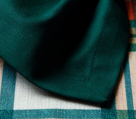 Corner of green table runner on plaid holiday table