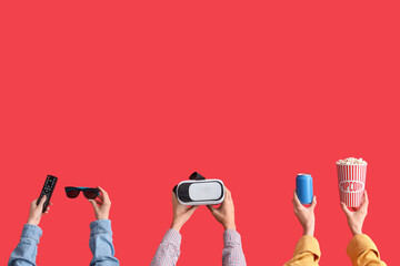 Many hands with VR glasses, bucket of popcorn and TV remote on red background