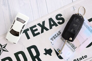 Remote control car keys on Texas license plate with driver license. Concept of driving in Texas....