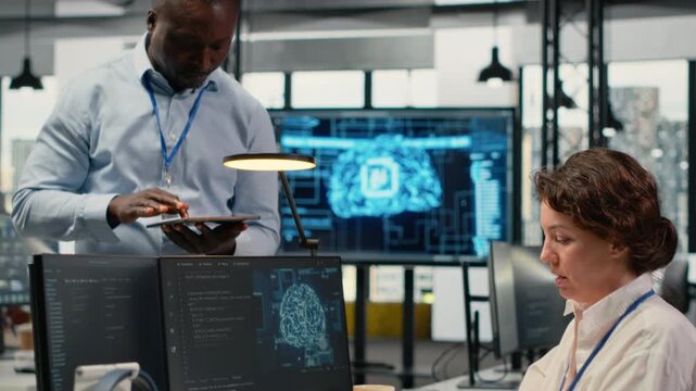 Manager talking with intern in office, using specialized hardware to accelerate complex AI calculations. Team leader teaching trainee how to manage machine learning training datasets, camera B