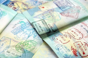 Many open passport pages with lots of visas and entrance stamps from various countries passport control. Concept of travel and tourism worldwide