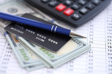 Credit card and pen with US dollar currency money bills banknotes on calculations document background. Business, financial operations and accounting in United States of America