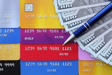 Credit cards and pen with US dollar currency money bills banknotes. Business, financial operations and accounting in United States of America