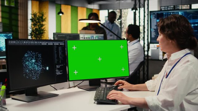 Green screen PC used by technician in office using AI to optimize company systems performance. Worker in startup office uses artificial intelligence tech on mockup computer to automate tasks, camera A