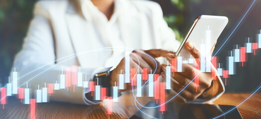 In a contemporary office, a business person in a suit focuses on their smartphone, surrounded by graphics illustrating stock market trends, highlighting attention to financial data and analysis.