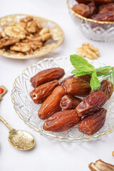 Bowl with dried dates on light background