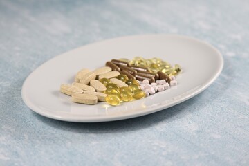 Plate full of 25 essential multivitamins and minerals tablets with maca root, panax ginseng. Cod...