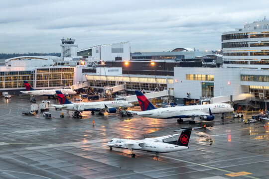 Aerial view of an Air Canada De Havilland Canada Dash 8-400 (Q400) and Delta Air Lines aircraft at Seattle-Tacoma International Airport on a rainy evening - Seattle, Washington, USA