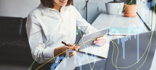 Young businesswoman smiles while using a digital tablet to read emails and investigate new business applications in her modern office. The setting features contemporary decor and greenery.