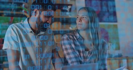 Leaning man in short-sleeve and woman in plaid reviewing code on laptop at desk, binary overlay