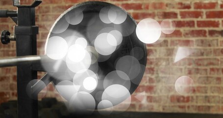 Showing large metal bell sitting on black clamp in studio, with soft bokeh circles