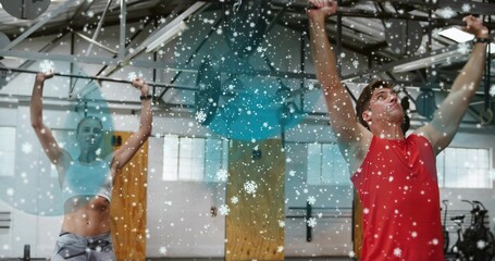 Pulling man in red top on pull-up-rig in gym with woman wearing white-bra, snowflakes, copy space
