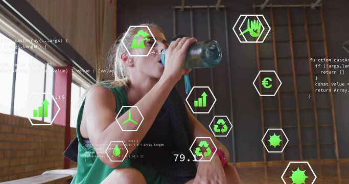 Drinking woman wearing green top and towel, resting on gym bench with reusable bottle and overlays - Powered by Adobe