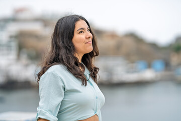 Obraz premium Young woman enjoying a peaceful walk by seaside