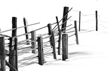 Composition of a wooden fence standing in a snowy field
