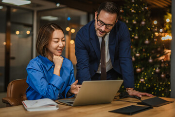 Business colleagues collaborating late in office with manager mentoring
