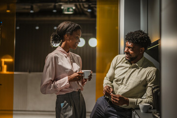 Colleagues having coffee break and friendly conversation at office