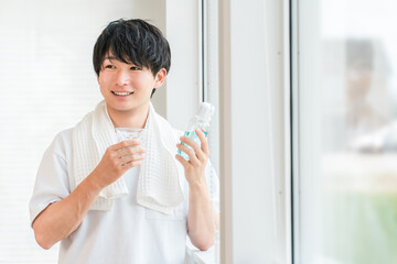 A young Asian man taking care of his bad breath with morning mouthwash