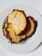 sponge roll cake with grated cheese filling and sprinkles chocolate topping. 
