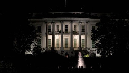 Obraz premium Nighttime view of the Whitehouse with its lights on, showing the buildings features and the dark sky above in Washington DC