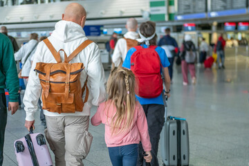 Travelers family with children, suitcases, and backpacks in airport terminal, ready for...