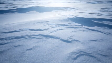 A snow covered field with shadows and sunlight creating a wintery and cold landscape view scene
