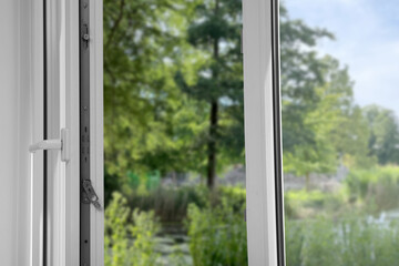 Obraz premium Open window, closeup. Green garden, view through glass