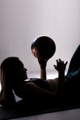 Silhouette of a young female basketball player holding a ball