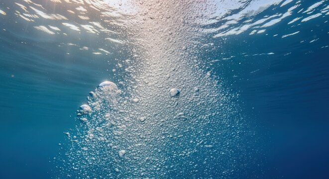 View from underwater, showing rising bubbles, sunlight filtering down, in shades of blue - Powered by Adobe