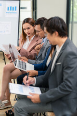 Group of business people discussing business plan in office conference room. Project planning, creative brainstorming, discussing ideas, using documents, digital devices.