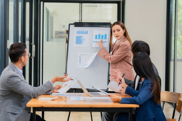 Group of business people discussing business plan in office conference room. Project planning, creative brainstorming, discussing ideas, using documents, digital devices.
