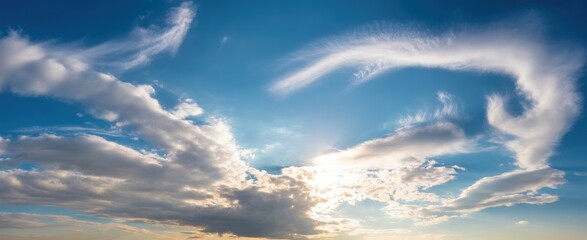 Dramatic sky clouds forming abstract shapes against blue sky