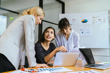 Business team analyzing data and marketing strategy in modern office, brainstorming ideas for project success using laptops and charts, teamwork collaboration for corporate growth
