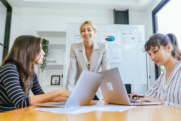 Business team analyzing data and marketing strategy in modern office, brainstorming ideas for project success using laptops and charts, teamwork collaboration for corporate growth