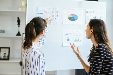 Business team analyzing data and marketing strategy in modern office, brainstorming ideas for project success using laptops and charts, teamwork collaboration for corporate growth