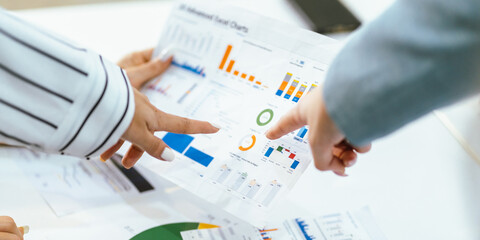 Business team analyzing data and marketing strategy in modern office, brainstorming ideas for project success using laptops and charts, teamwork collaboration for corporate growth