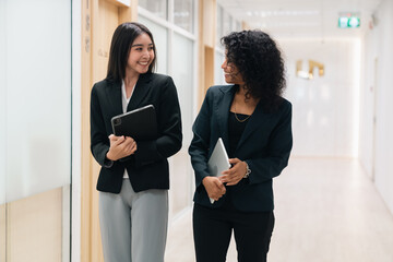 Professional business team having meeting discussing corporate strategy and project results using laptop in modern city environment showing teamwork leadership confident collaboration spirit