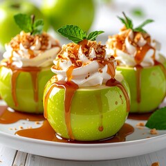 Bright green apples filled with whipped cream and drizzled caramel, garnished with mint on a white plate