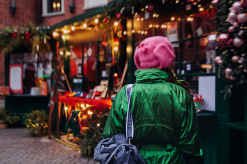 Obraz premium Christmas market with illuminated food stalls, gift shops and kiosks, New Year outdoor fair decorations, garlands and festoons, Xmas atmosphere, retail and store illumination, decor in Europe city