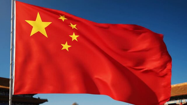 A red flag adorned with five yellow stars billows against a clear blue sky with architectural elements featuring golden roofs visible in the background