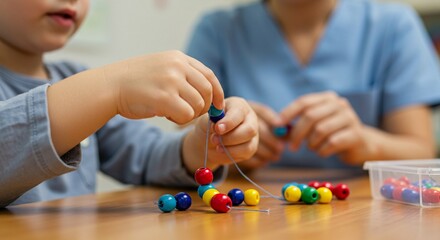 Child strings colorful beads during therapy session with adult. Beads vary in color promoting dexterity, color recognition, and visual motor skills.