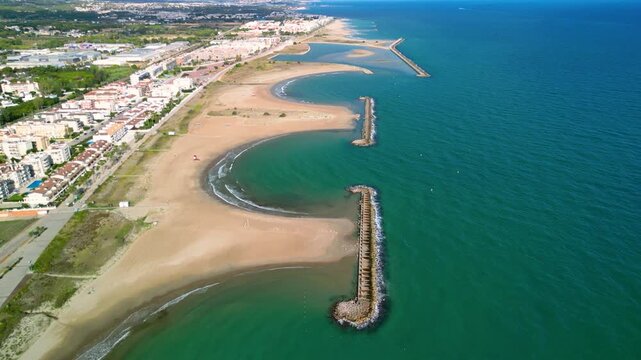 4K Aerial cinematic view of Cunit beach and Mediterranean Sea coastline in Catalonia, Spain. Wide sandy beach, turquoise water and summer vacation atmosphere.
