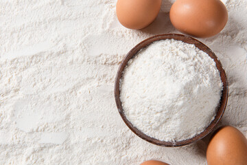 Close-up of white flour with eggs background.