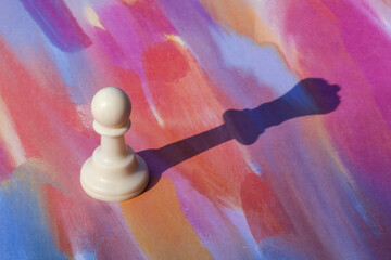 Chess pawn with the shadow of of a queen