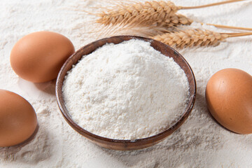Close-up of white flour with eggs background.