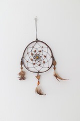 A dreamcatcher used as decoration on a white wall in Rio de Janeiro.