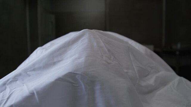 A corpse on a gurney in a hospital morgue