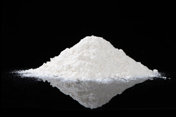 heap of white flour isolated on black background