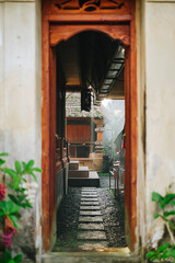 Traditional Balinese Courtyard View Through Carved Wooden Doorway