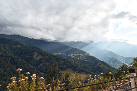Majestic mountain landscape with rolling hills, a misty valley, and dramatic clouds over a tranquil alpine scene inviting exploration and reflection
